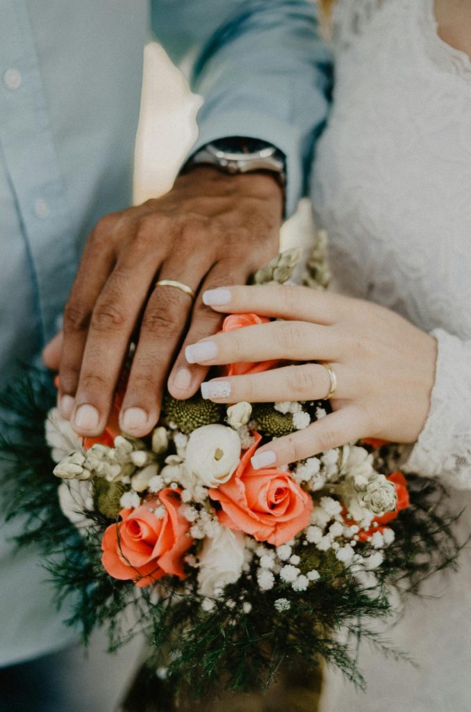 Man and Woman's Hands on Top of Ball Bouquet
